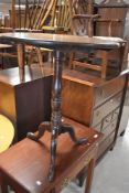 A 19th century oak snap-top stem table, the circular planked top above the snap-top action and