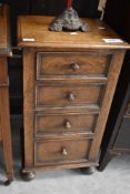 An antique effect oak four drawer bedside chest with turned knob handles and turned bun feet 76cm