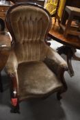 A Victorian mahogany spoon-back armchair, the deep-buttoned and upholstered back within a scroll