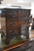 A reproduction mahogany serpentine fronted bedside chest of drawers, 58cm
