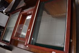 A group of three modern stained pine, glass and mirrored glass wall mounted display cabinets,