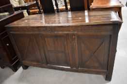 An 18th century oak three panel coffer, of hinged rectangular form, the moulded plank top opening to