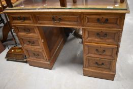 An early 20th century light oak pedestal desk, with inset tooled brown leather skiver and