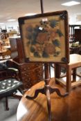 A 19th century mahogany pole screen, the printed material screen within a moulded frame and under