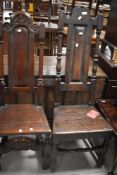 An early 18th century oak side or hall chair, having a scroll carved and pierced arched top rail
