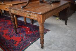 A Victorian oak library table, of rectangular form with long drawer to each end and raised on turned