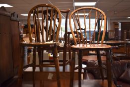 Two elm seated stick/hoop back chairs, with solid seats and spindle supports, glued repairs to one