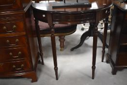 A reproduction mahogany demi-lune side table, serpentine fronted and raised on turned and reeded