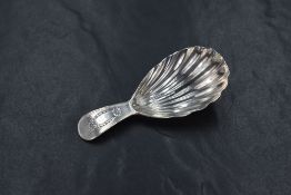 A George III silver caddy spoon, of traditional form having scalloped bowl with bright cut engraving