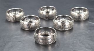A cased set of six Edwardian silver napkin rings, having engraved floral decoration with