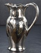 A silver plated Art Nouveau style jug of traditional form, having embossed tulips creating a