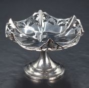 A George VI silver pedestal bon bon dish, having a lobed floral design pieced rim, raised on a