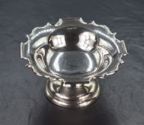 An early George V silver pedestal bon-bon dish, having a Chippendale style rim raised on a