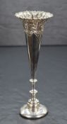 A late 19th/early 20th century silver vase, of fluted form having a flared rim with embossed