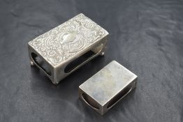 A Victorian silver matchbox case, having embossed decoration to the top raised on four ball feet,