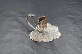 A William IV silver candle holder, the leaf motif base with the candle holder and handle formed from