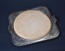 A 20th century silver plated cheese board, of square form having crimped rim and scroll handles with