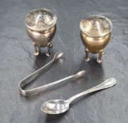 A pair of George V silver pepperettes, of flared form having planished decoration, raised on four