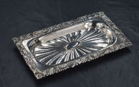 A 20th century silver pin tray, having decorative embossed scroll work to rim with fluted centre and