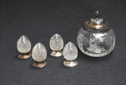 A set of four silver mounted and cut glass salts and pepperettes, of egg motifs having silver filled