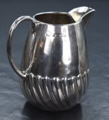 A Victorian silver cream jug, of slightly bulbous form having a narrow spout opposed by c-curve