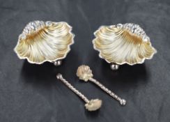 A cased set of Edwardian silver salts, the two salts in the form of shells raised on three ball