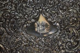 An Edwardian silver decorative tray, having an embossed floral scroll rim, further embossed