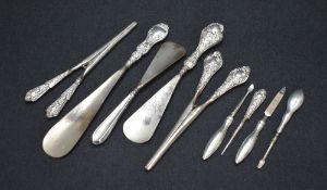 An assortment of silver handled dressing wears, comprising shoe horns, glove stretchers and manicure