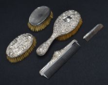 An assortment of early 20th century silver mounted vanity wears comprising a hair brush, two clothes