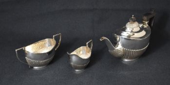 A late Victorian silver three piece tea set, comprising a tea pot, sugar and milk each of oval