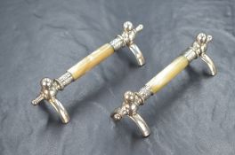 A pair of mother-of-pearl and white metal knife rests, of traditional form having central mother-