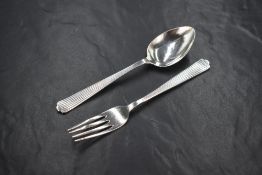 A George VI cased silver christening set, comprising a spoon and fork, having decorative line work