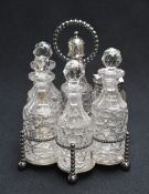 A 20th century silver plated and cut glass condiment set, the six piece set within a lobed stand