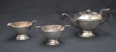 An Elizabeth II silver three-piece tea set comprising a tea pot, sugar and cream, all of rectangular
