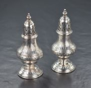 A pair of Victorian silver pepperettes, of bulbous form having decorative line work and scroll