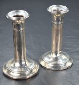 A pair of Edwardian silver candlesticks, having step moulded sconces and moulding to the stems,
