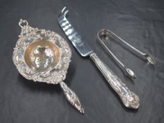 An Edwardian silver tea strainer, of traditional form having embossed floral scroll decoration,
