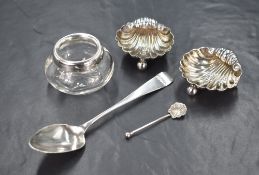 A pair of Edwardian shell motif salts, raised on three ball feet with a shell motif spoon, marks for