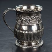 A George III silver tankard, having a slightly flared rim with embossed grape vine motif decoration,