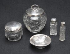 An assortment of silver capped cut glass vanity table wears, comprising scent bottles and cosmetic