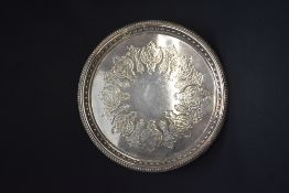 A large silver plated serving tray, of circular form with egg and dart rim having central decorative