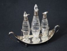 An Edwardian silver mounted cut glass condiment set, the fluted bodies with silver mounts creating