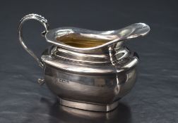 An Edwardian silver sauce boat, of rectangular form having a flared rim, shallow spout opposed by