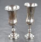 Two Edwardian silver Kiddush cups, both of traditional form having decorative engraving, raised on