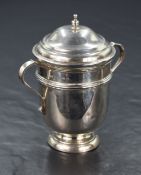 A George V silver cup and cover, of traditional form having a step moulded cover with finial, C-