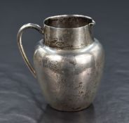 An early George V silver cream jug, of circular form with straight rim, narrow spout opposed by a