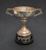 A George V silver trophy cup, of traditional for having angular handles, raised on a knopped stem