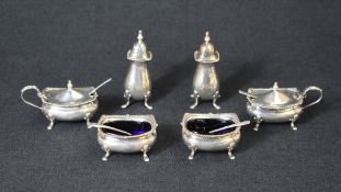 An Edwardian cased silver condiment set, comprising two salts, mustards and pepperettes with spoons,