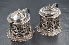 A pair of Victorian silver salts, of circular form having scroll motif finials, moulded lids and