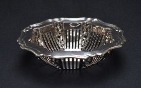 An Edwardian silver fruit bowl, having a lobed step moulded rim and decorative pierced sides,